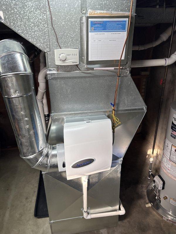 Installed a new gas furnace with a condensing PVC vent and secured condensate drain line, set on a drip pan with new galvanized supply plenum and ductwork transitions. Installed an AprilAire humidifier with humidistat control, connected the associated water supply and drain piping, and completed the electrical and low-voltage connections with the wiring properly secured. Verified the water heater connection and gas control valve, completed unit labeling, and left the service log in place at the equipment.
