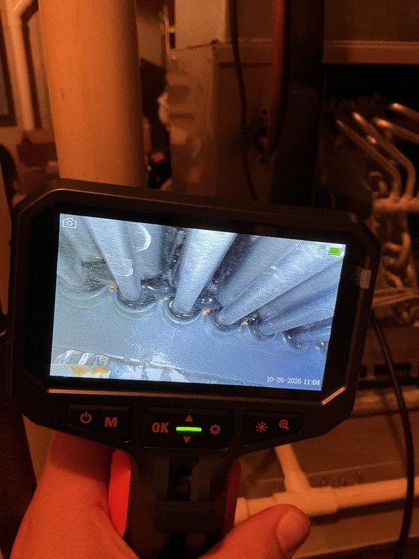 Performed annual heating tune-up on a 15-year-old Bryant furnace with whole-home humidifier. Inspected the evaporator coil and surrounding cabinet using a borescope, which revealed significant frost and ice accumulation on the coil tubes and fins, indicating restricted airflow or a refrigerant-side issue that should be further evaluated. Documented findings with photos and recommended follow-up diagnostics of the cooling system.