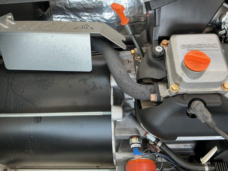 Performed a complete tune-up on a Generac standby generator with an Evolution 2.0 controller, including inspection of the engine compartment, oil system (fill cap, dipstick, and filter), hoses, wiring, and heat shield. Components were found clean and in good condition, with no frost or damage, and only minor surface rust speckling on a flexible hose and light paint cracking on the alternator housing, neither affecting operation. The unit was left ready for standby operation.