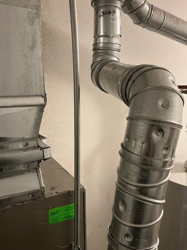 Responded to a complaint of loud rattling noises from the gas furnace. Inspected the furnace cabinet, access panel, supply plenum, and galvanized flue/vent piping, and identified vibration and contact points in the venting and ductwork as the likely source of the noise. Secured and re-supported the vent piping and clamps, verified the plenum and transition connections were tight, and reinstalled the access panel. Cycled the furnace through a heating call and confirmed quiet operation with no remaining rattling.