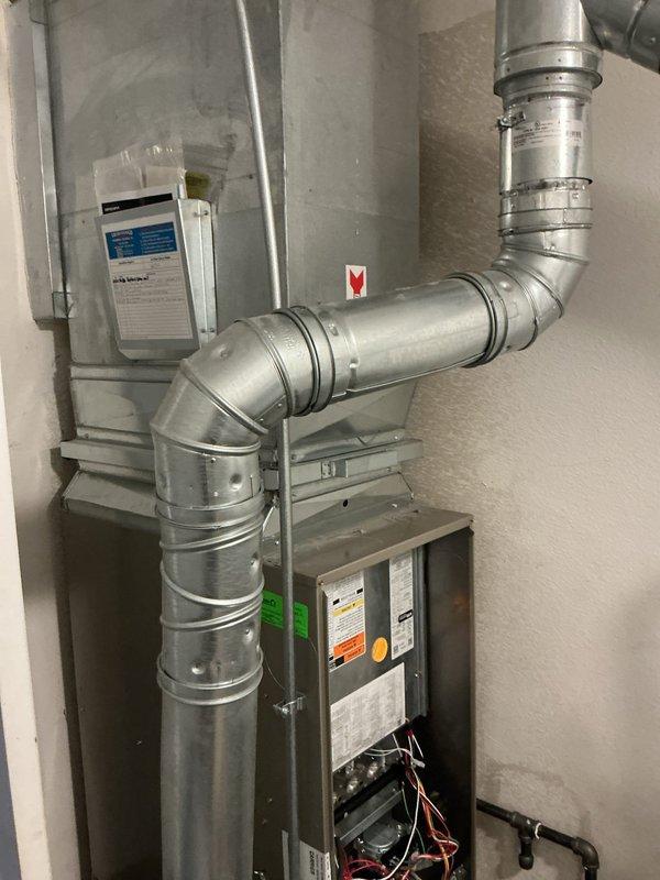 Responded to a complaint of loud rattling noises from the gas furnace. Inspected the furnace cabinet, access panel, supply plenum, and galvanized flue/vent piping, and identified vibration and contact points in the venting and ductwork as the likely source of the noise. Secured and re-supported the vent piping and clamps, verified the plenum and transition connections were tight, and reinstalled the access panel. Cycled the furnace through a heating call and confirmed quiet operation with no remaining rattling.