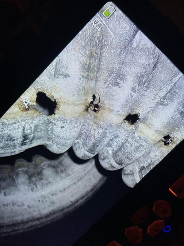 Responded to a no-heat call on a 20-year-old Goodman furnace where the thermostat called for heat but the unit would not fire, while the blower operated normally. Performed a borescope inspection of the heat exchanger and found multiple burn-through holes and perforations along the seam with heavy corrosion and scaling, confirming a cracked/failed heat exchanger. The furnace was deemed unsafe to operate due to carbon monoxide risk and was shut down, with replacement recommended.