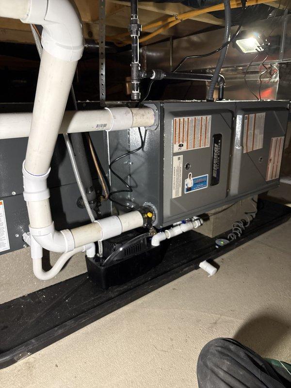 Installed a new horizontal gas furnace in the crawl space on a drain pan, with sheet metal supply plenum connected to existing ductwork. Connected gas piping, electrical supply, and PVC condensate drain with condensate pump, and verified all warning labels and installation placards were in place. Unit appears clean and properly secured with no visible damage or leaks.