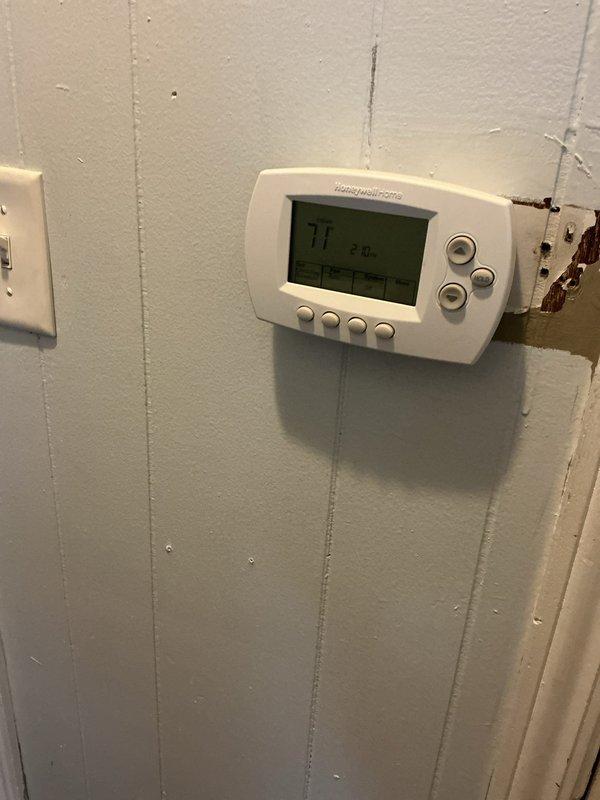 Replaced the failed Honeywell Home digital thermostat with a new unit, navigating the existing low-voltage wire run routed through the ceiling, attic, and back down through the closet wall. Verified proper wiring termination at the subbase and confirmed the display, calibration, and system operation were functioning correctly after installation.