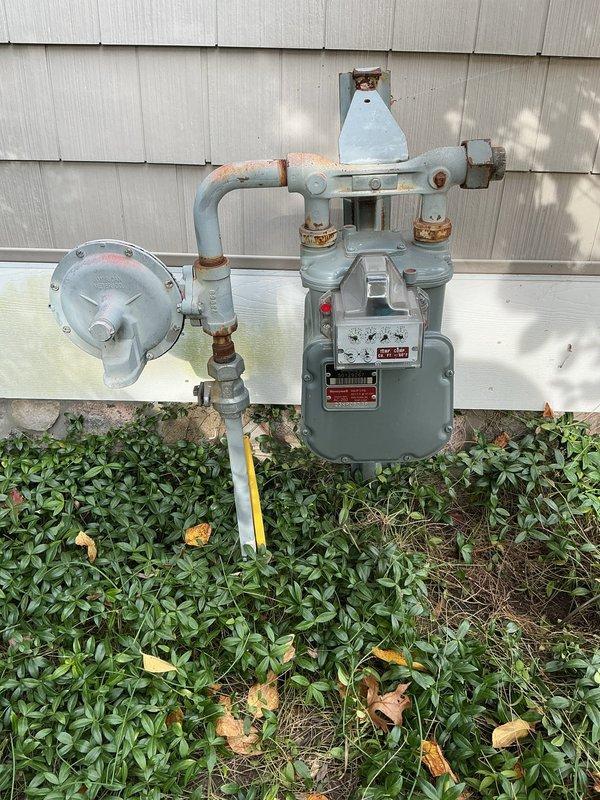 Capped and eliminated the abandoned gas line leading to the old meter, isolating it from the active gas supply and securing it with a threaded cap. Performed a leak test on the capped connection to confirm a gas-tight seal, with the remaining gas piping and meter assembly left in service.