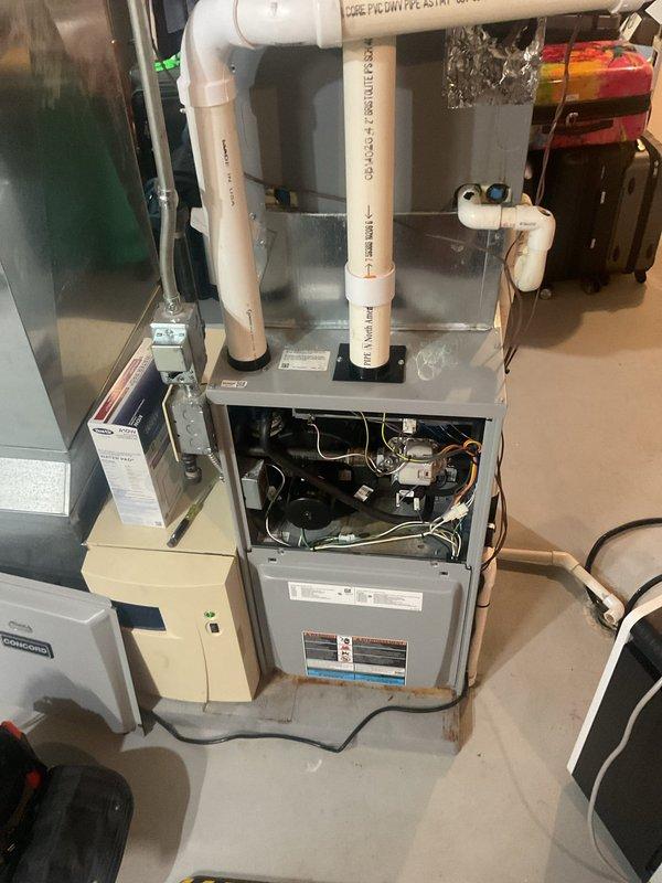 Performed a Furnace Super Tune-up on a 9-year-old Heatcraft gas furnace with an attached whole-house humidifier. Removed the upper access panel and inspected the blower motor, wiring harnesses, and control assembly, then verified proper operation of the heating system. Checked the condensate drain line and PVC venting for secure connections, and noted light rust staining on the concrete floor at the base of the furnace cabinet for monitoring.