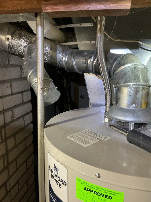 Responded to a Bradford White gas water heater (approx. 9 years old) reporting excessive outlet temperature and a recurring temperature limit fault. Inspected the unit and flue/venting, and flushed the tank, which produced discolored, sediment-laden discharge indicating heavy mineral and sediment buildup likely contributing to overheating and thermostat/ECO limit trips. Restored the unit to operation after the flush and verified the temperature control and burner function.