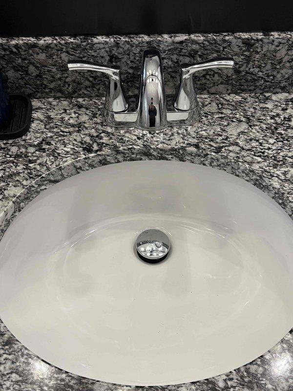 Replaced the bathroom faucet with the customer-supplied unit, including disconnecting the existing supply lines and verifying leak-free operation. Removed the corroded tub drain flange and stopper assembly and installed a new drain and stopper. Cleared the kitchen sink clog and confirmed proper drainage.