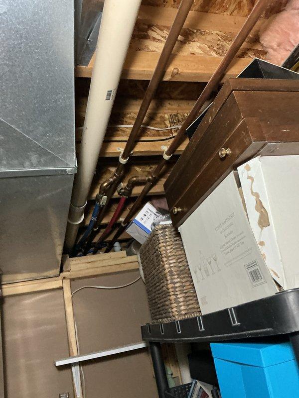 Performed an on-site evaluation of the existing water heater, which had been reported as failing and potentially non-functional, to determine replacement requirements. Inspected the surrounding utility area, including the PVC-DWV drain piping, copper water supply lines, flexible supply connectors, and overhead ductwork, and documented existing conditions with photographs to support replacement planning. No visible frost, rust, or cracking was observed on the accessible piping or ductwork.