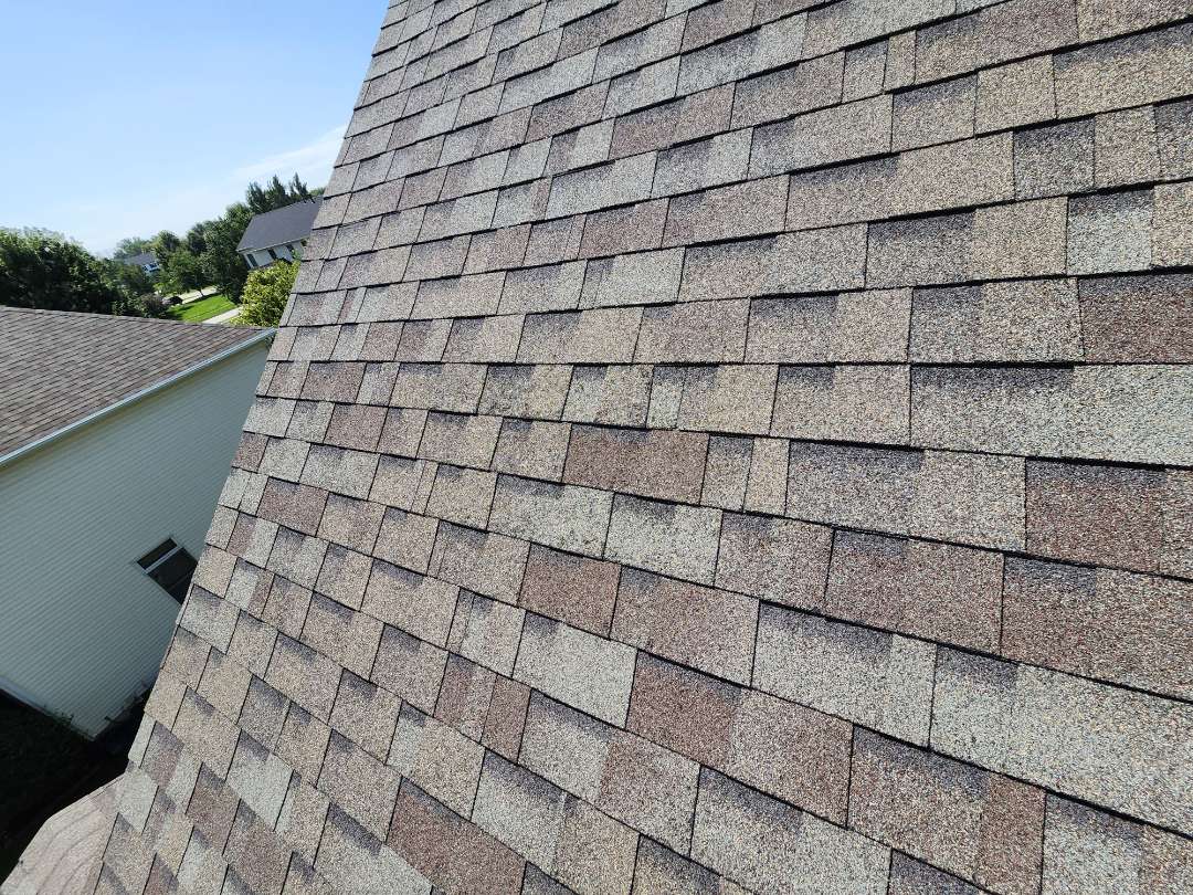 Wes Des Moines homeowner contacted us for a second opinion on hail damage. We conducted a thorough inspection, finding no damage to downspouts, gutters, soft metals, or siding. The roof showed normal wear and tear, with traffic waves from previous contractors. The roof, approximately 8 to 10 years old, has at least another 8 to 10 years of good use. No replacement is recommended; only maintenance and necessary repairs are advised. The paint window wraps were intact, and there were no weather-related damages.
