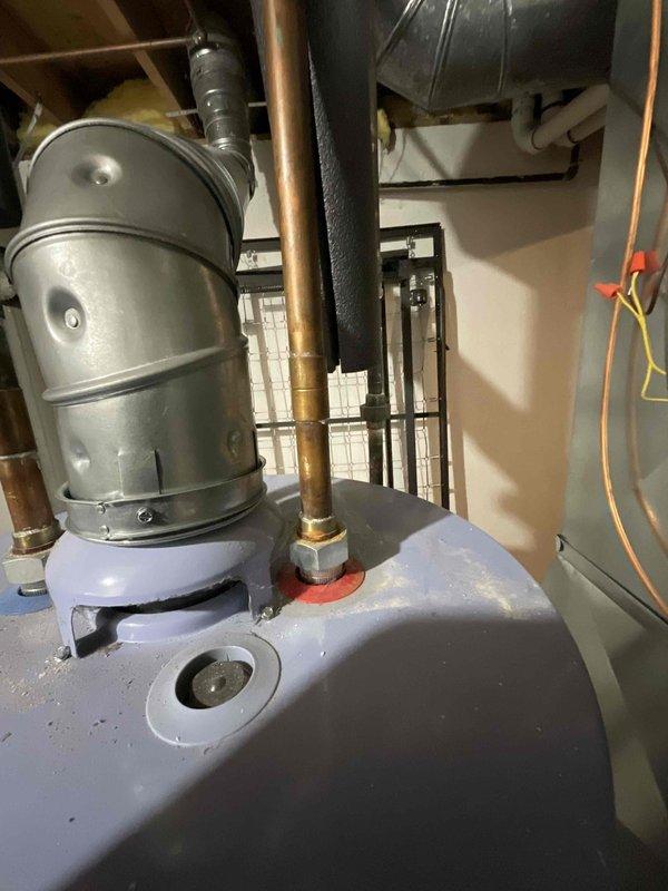 Inspected leaking 40-year-old hot water heater that has been leaking for one week in a specific area. System evaluation revealed aged tank with copper piping connections and signs of water damage. Recommended full replacement of water heater unit to resolve ongoing leak and prevent potential future failures.