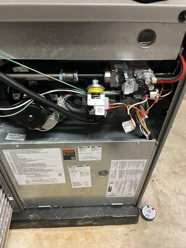 Performed annual furnace maintenance as part of customer's membership plan. Inspected thermostat operation (confirmed 72°F reading) and examined interior furnace components including gas valve, wiring harnesses, and blower assembly. System functioning properly with no issues identified; documentation photos taken of thermostat and internal components for service records.