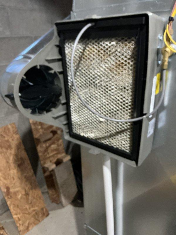 Conducted annual home maintenance service on HVAC system with pad-mounted unit and filterless design operating at approximately 10% efficiency. Inspected Lennox furnace and associated ductwork, noting significant dust accumulation on mesh filter element requiring replacement. System was operational despite expired maintenance appointment; documented condition with photographs for service record.