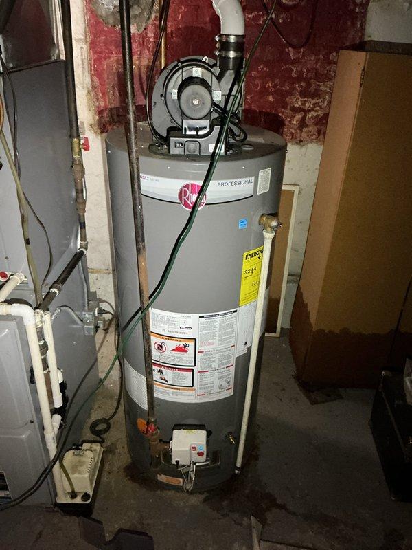 Responded to service call for non-functioning Rheem water heater (8+ years old) located in basement that would not ignite following a flood event. Upon inspection of the unit, observed potential damage to the flammable vapor ignition detection system as indicated by warning label on lower portion. Determined flood water had affected ignition components, requiring replacement of damaged parts to restore hot water service.