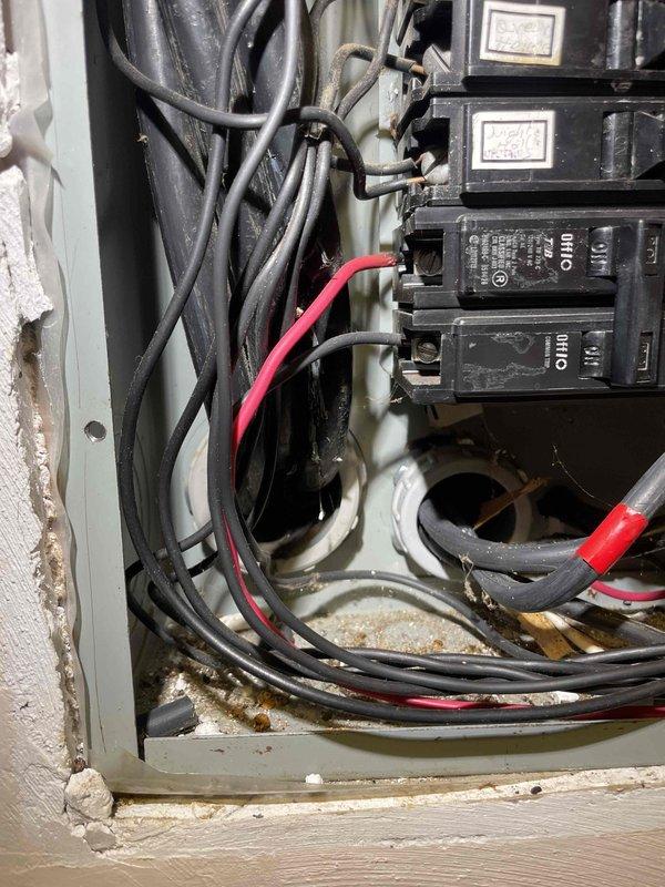 Completed site assessment for potential mini-split installation. Inspected electrical panel which shows signs of aging with visible corrosion at wire entry points and evaluated exterior mounting location near deck where condenser unit would be installed. Documentation includes photos of the electrical panel capacity and proposed installation area for system planning.