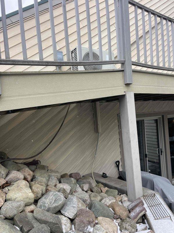 Completed site assessment for potential mini-split installation. Inspected electrical panel which shows signs of aging with visible corrosion at wire entry points and evaluated exterior mounting location near deck where condenser unit would be installed. Documentation includes photos of the electrical panel capacity and proposed installation area for system planning.