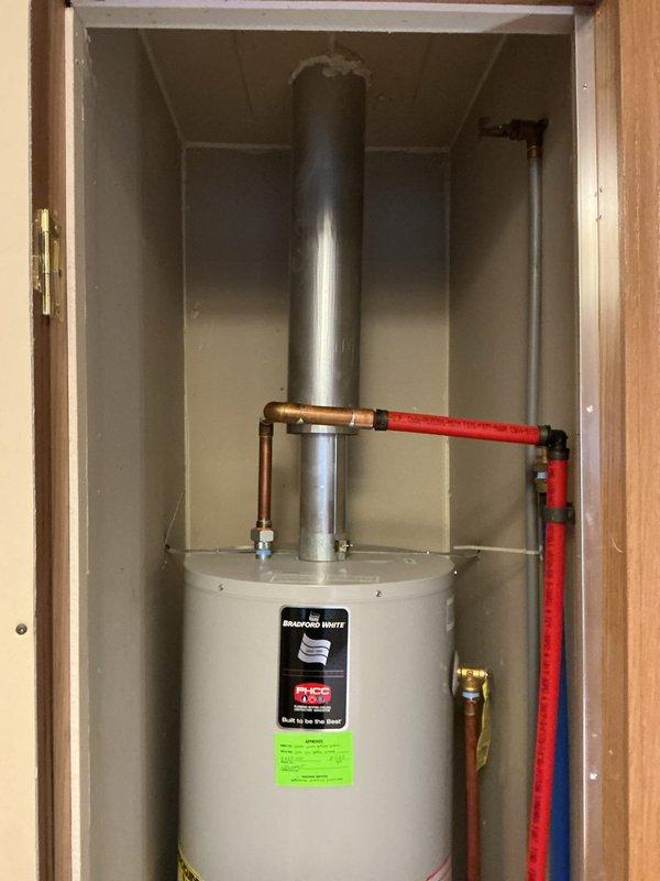 Diagnosed and replaced failed Bradford White tanked water heater that was not producing hot water. Installed new unit with proper copper and PEX connections, ensuring proper venting through metal exhaust pipe to ceiling. Completed installation with gas line connection and verified system operation before finalizing service.