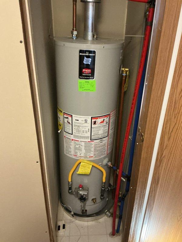 Diagnosed and replaced failed Bradford White tanked water heater that was not producing hot water. Installed new unit with proper copper and PEX connections, ensuring proper venting through metal exhaust pipe to ceiling. Completed installation with gas line connection and verified system operation before finalizing service.