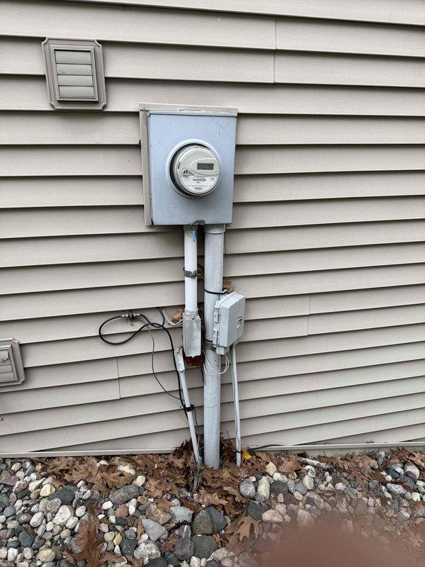 Conducted site assessment for potential installation of a 50-amp generator inlet with panel interlock system to accommodate customer's two Champion 4500-W inverter generators operated in parallel. Also evaluated existing ceiling light location for fan installation with existing wiring. Documented electrical panel condition and exterior mounting options for HOA approval documentation, noting current meter configuration and available space for generator inlet placement.