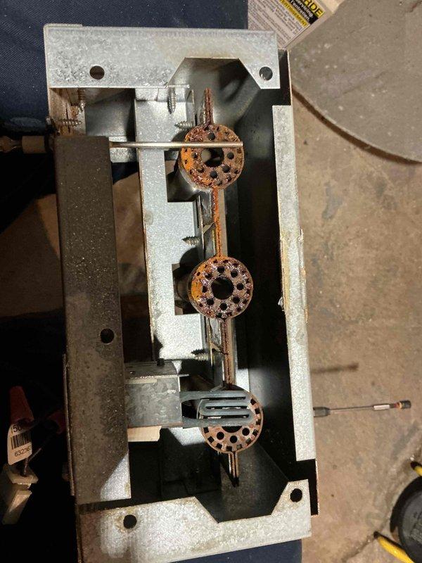 Responded to service call regarding furnace blowing cool air. Inspection revealed significant corrosion on the burner assembly with extensive rust formation on flame distributors. Removed and replaced deteriorated burners and associated components to restore proper heat generation and airflow.