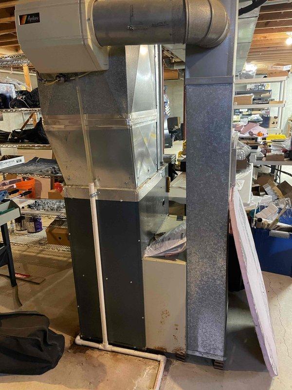 Completed Home Show appointment evaluation of existing A/C system. Inspected aging air handler unit installed in basement with visible wear on lower panels. Documented current setup including galvanized ductwork connections, condensate drainage system, and R-5.0 insulation. Photos taken of complete system for replacement estimate preparation.