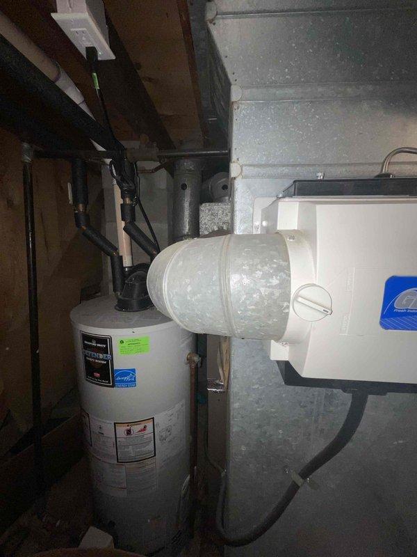Conducted assessment of non-operational 15-year-old natural gas furnace in basement mechanical room. Inspection revealed electrical component failure requiring complete system replacement. Documented current installation configuration including ductwork connections and proximity to water heater for proper replacement unit specifications.