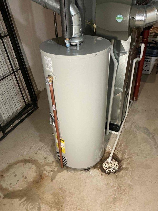 Successfully installed a 40-gallon tanked water heater in residential basement utility area. Connected unit to existing copper plumbing and properly secured pressure relief valve. Installation included mechanical permit and completed reconnection of all required ductwork to HVAC system.