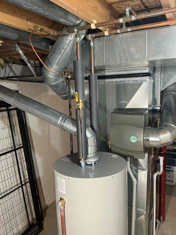 Successfully installed a 40-gallon tanked water heater in residential basement utility area. Connected unit to existing copper plumbing and properly secured pressure relief valve. Installation included mechanical permit and completed reconnection of all required ductwork to HVAC system.