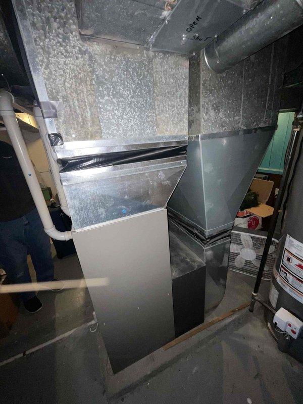 Conducted comprehensive assessment of 21-year-old natural gas furnace in customer's basement that is not functioning properly. Evaluation revealed aging system with standard metal ductwork configuration and visible wear. Provided replacement options under current Furnace & Air Conditioner promotion while customer is exploring competitive quotes and cash discount options.