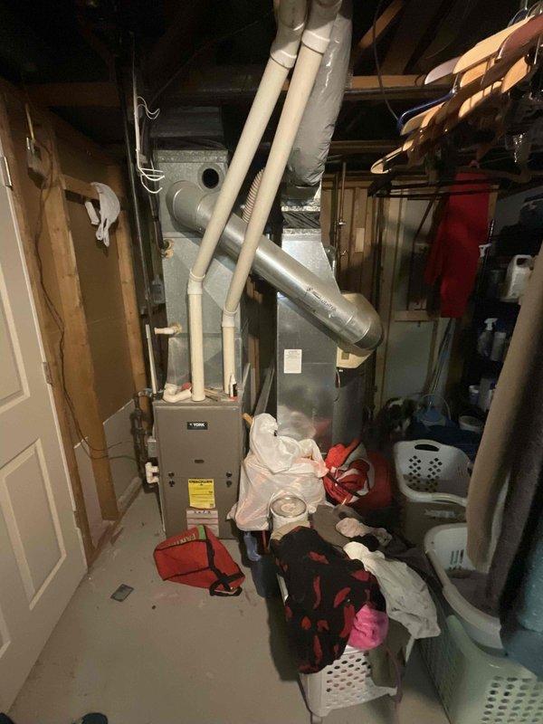 Conducted comprehensive assessment of existing HVAC system including indoor furnace unit with connected PVC ventilation/drainage pipes and outdoor AC condenser. System appears to be aging with visible wear on the outdoor unit (rust/dirt accumulation on top surface). Recommendation provided for complete system replacement based on current condition and efficiency concerns. Quote prepared under reference #126393-01 following home show appointment request.