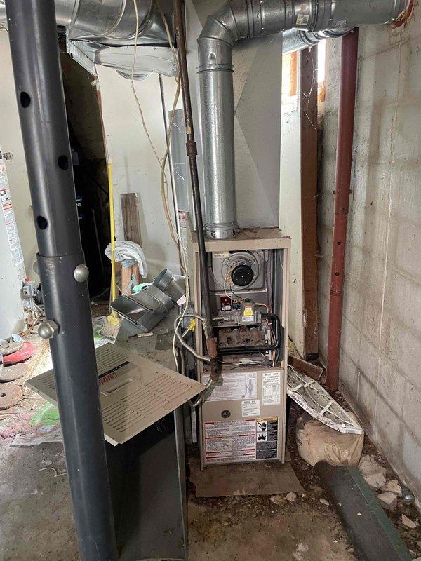 Conducted inspection on 12-year-old Lennox furnace reporting ignition failure. Diagnosed non-functioning burner assembly while blower motor remains operational. Recommended full system replacement due to age and condition, noting existing ductwork requires modifications to accommodate new equipment. Photos documented current installation configuration in basement utility area.