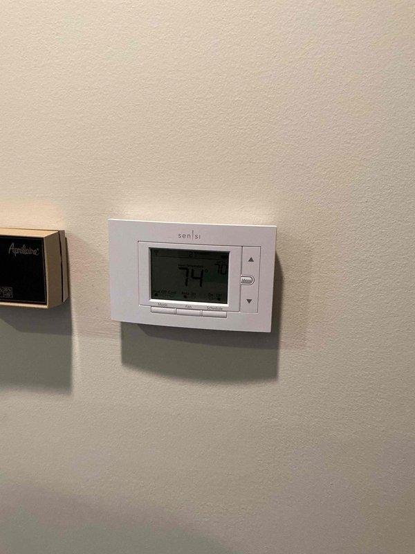 Successfully installed new Emerson Sensi programmable thermostat, replacing existing Bryant unit. Verified proper functionality with temperature reading of 74°F and confirmed all programmable features (home/away/sleep modes) were operational.