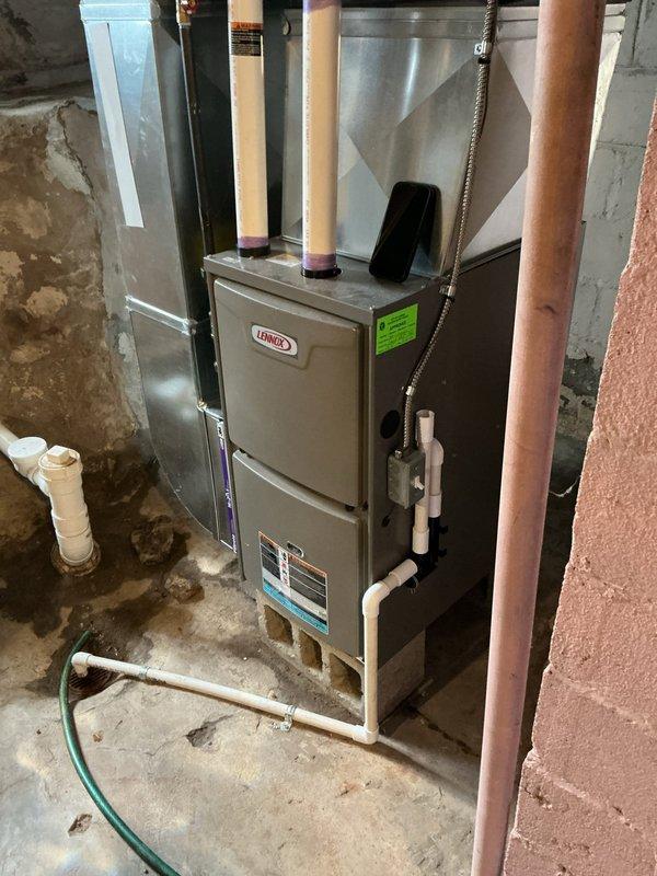 Performed annual heating maintenance on Lennox furnace system located in basement. Inspected unit for proper operation, examined ductwork connections, and evaluated surrounding environment for moisture issues. Noted aging concrete walls with signs of previous water damage that should be monitored but are not currently affecting furnace performance.