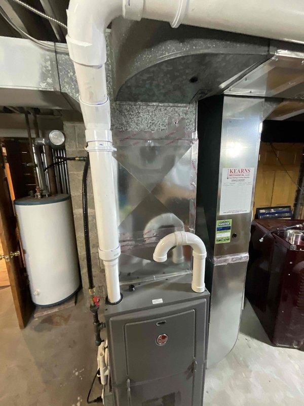 Conducted estimate for replacement of aging HVAC system located in basement utility room. Current setup includes older furnace unit with connected PVC ventilation piping, metallic ductwork, and adjacent water heater. Documented existing equipment condition and layout for proper sizing and configuration of replacement system.