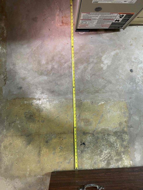 Conducted measurement assessment for replacement of 25+ year old furnace and A/C system located in basement. Unit is currently operational but at end of serviceable lifespan. Measurements taken of installation area included vertical clearances (approximately 46") and floor space dimensions to ensure proper sizing for new equipment.