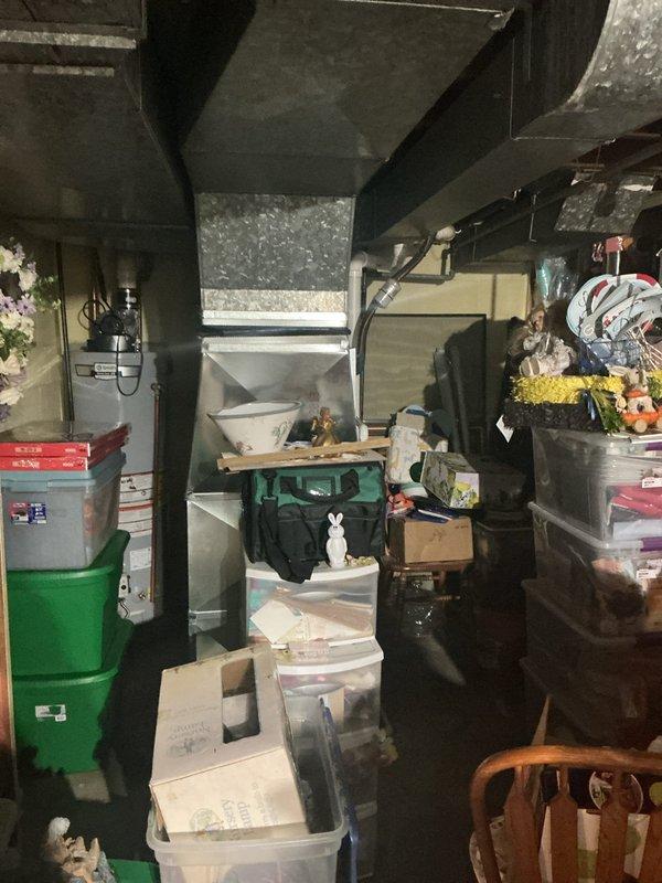 # HVAC Maintenance - ACM Service Summary

Completed annual cooling maintenance service on residential HVAC system. Accessed equipment through confined crawl space storage area and performed comprehensive inspection of cooling components. Documented significant rust and corrosion present on evaporator coil fins, indicating prolonged moisture exposure and age-related deterioration. Photographed corroded heat exchanger elements showing brown and orange oxidation on triangular-shaped metal fins arranged in V-formation within equipment cabinet. Inspected surrounding ductwork, insulation panels, and mechanical enclosure components. System operational at time of service with no immediate performance issues reported. Recommended monitoring equipment performance and consideration of future component replacement due to advanced corrosion on coil assembly.