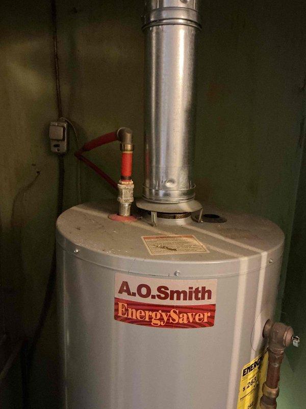 # Service Report: Tanked Water Heater Replacement

Responded to no hot water complaint on 10-year-old A.O. Smith tank-style water heater. Upon diagnostic inspection, determined unit had reached end of serviceable life and was no longer producing hot water due to failed heating element and sediment accumulation. Recommended full replacement rather than repair given age and condition of existing equipment.

Removed and properly disposed of old water heater from utility closet installation. Installed new A.O. Smith EnergySaver model tank water heater with appropriate BTU capacity for household demand. Connected new unit to existing water supply lines using copper piping with shutoff valve at inlet. Verified proper clearances for combustion air and maintenance access within confined closet space.

Installed metallic vent pipe and flue assembly to exhaust combustion gases safely through existing ventilation pathway. Ensured all gas connections were properly sealed and tested for leaks using