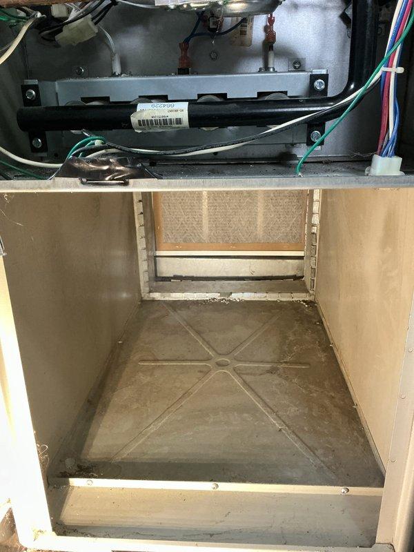 # Service Report

Responded to service call for furnace making clicking noise and short cycling. Upon arrival, performed diagnostic inspection of forced air furnace system. Accessed interior compartment through service panel to examine blower assembly, motor, and control components. 

Inspected blower motor assembly and associated wiring harnesses for loose connections or damaged components that could cause clicking sounds. Examined electrical connections including control wiring, noting presence of multiple wire bundles and electronic control board. Checked motor mounting brackets and hardware for proper securement and potential vibration issues.

Investigated heat exchanger and burner compartment for debris accumulation or mechanical interference. Observed dust buildup on interior surfaces and base pan, which can contribute to operational issues. Inspected limit switches, flame sensor, and ignition system components for proper operation and potential causes of short cycling behavior.