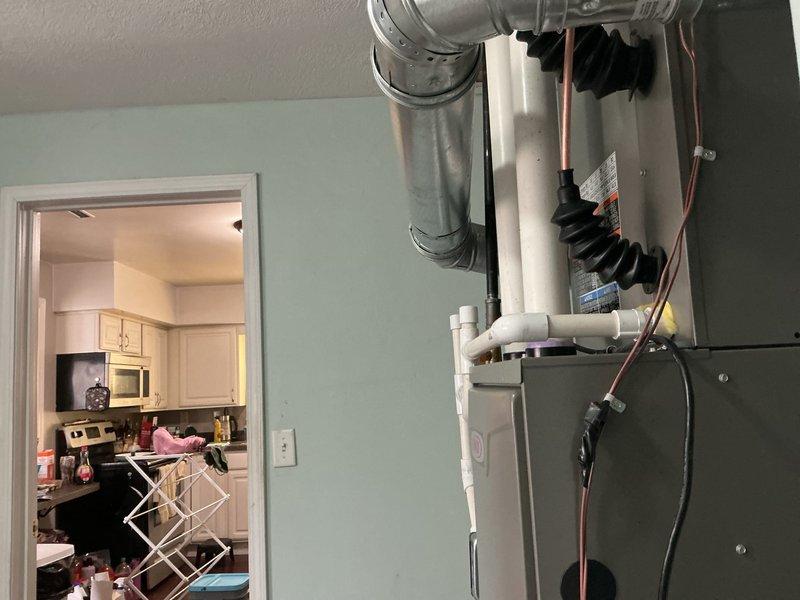 Completed full HVAC system installation including a 70,000 BTU Lennox furnace and 2.5 ton air conditioning unit with rear discharge configuration. Installed new metallic ductwork with elbow joints and support brackets, ran white PVC condensate drain lines from furnace to proper drainage point, and connected copper refrigerant lines between indoor and outdoor units. Installed chimney liner for proper venting, reconnected all electrical connections to panel box, and secured black flexible conduit and wiring along mechanical infrastructure. All plumbing connections, including water heater integration, were completed per code requirements. System tested and verified operational upon completion.