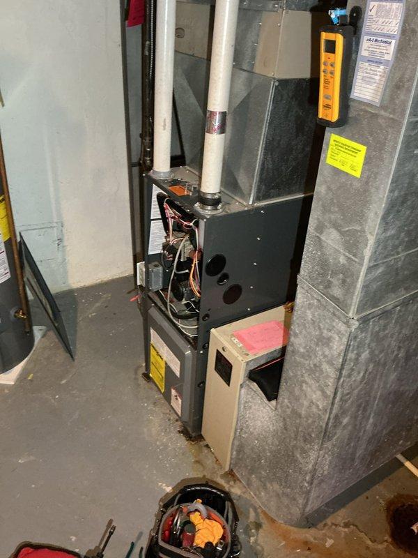 Responded to service call for second opinion on CO2 leak on 21-year-old furnace system located in basement. Upon inspection, discovered significant structural damage to air handler/ductwork with large irregular hole in side panel, compromising system integrity and creating potential for combustion gas leakage. Performed diagnostic testing using digital combustion analyzer to assess carbon monoxide and carbon dioxide levels. Documented extensive deterioration of ductwork with jagged metal edges and compromised seals. Noted water staining on concrete floor surrounding furnace base, indicating possible condensate drainage issues that may have contributed to metal corrosion over time. Photographed damaged components for documentation purposes. Given the age of equipment and extent of structural damage to critical components, advised customer that repair would require replacement of damaged ductwork sections and thorough evaluation of heat exchanger integrity to ensure safe operation and pr