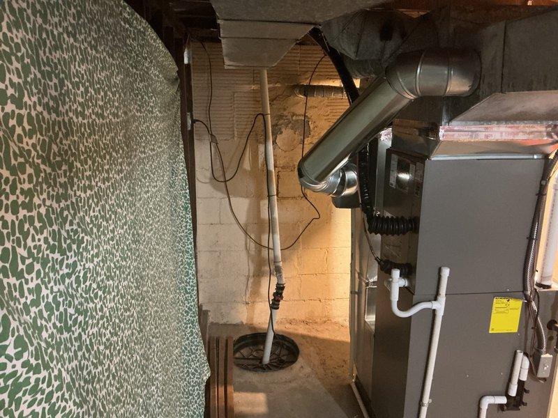 Completed full HVAC system installation including Lennox 70,000 BTU furnace and 2.5 ton air conditioning unit with rear discharge configuration. Installed furnace on platform in basement utility area with proper clearances, ran white PVC intake and exhaust venting vertically from unit, and connected refrigerant lines along wall with appropriate insulation. Fabricated and installed sheet metal ductwork with reinforced connections extending from furnace to distribution points throughout structure. Reconnected humidifier to new system and completed all electrical connections. Secured necessary mechanical permits prior to installation and documented completed work with photographs showing proper equipment placement, vent terminations, and ductwork routing.