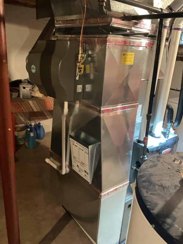 Completed annual heating maintenance on residential Lennox furnace system in basement utility area. Performed comprehensive tune-up inspection of all major components including heat exchanger, burner assembly, blower motor, and electrical connections. Verified proper operation of safety controls, tested ignition sequence, and confirmed adequate airflow through supply and return ductwork. Inspected ductwork connections and foil tape seals for integrity. System operating within manufacturer specifications with no deficiencies noted at time of service.