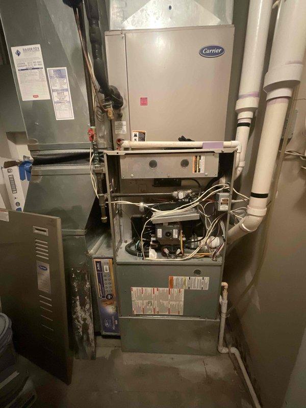 Responded to commercial HVAC replacement estimate for non-heating furnace system located in utility room. Assessed existing Carrier furnace and air handler configuration with associated electrical panel, refrigerant lines, condensate drainage, and ductwork connections. Documented current equipment condition, internal blower motor assembly, control components, and existing installation setup including PVC piping, copper lines, and electrical connections to provide comprehensive replacement quote for failed heating system.