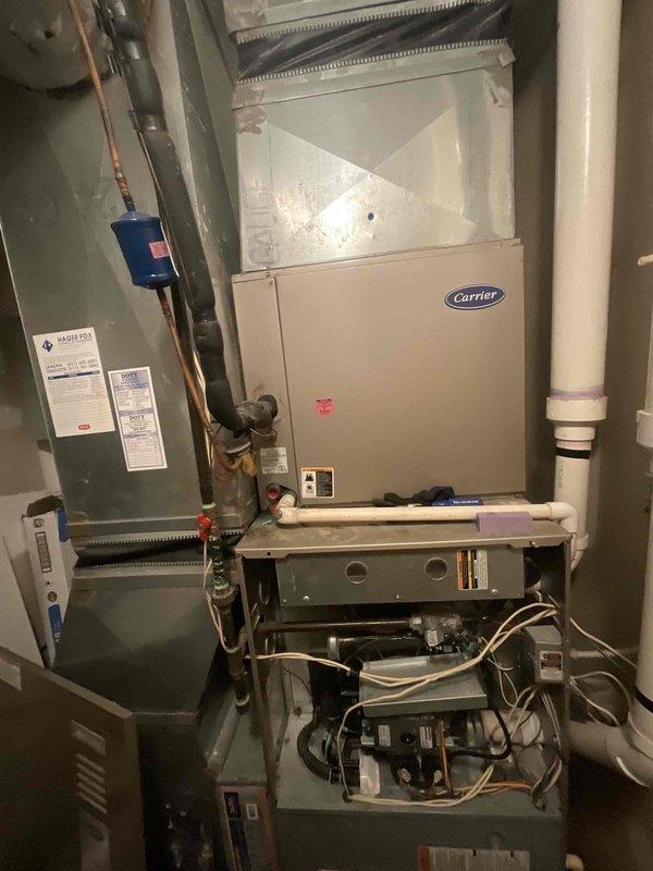 Responded to commercial HVAC replacement estimate for non-heating furnace system located in utility room. Assessed existing Carrier furnace and air handler configuration with associated electrical panel, refrigerant lines, condensate drainage, and ductwork connections. Documented current equipment condition, internal blower motor assembly, control components, and existing installation setup including PVC piping, copper lines, and electrical connections to provide comprehensive replacement quote for failed heating system.