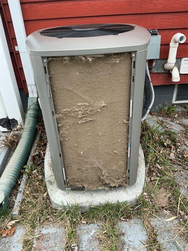 Completed annual cooling maintenance on outdoor condensing unit. Opened access panel and discovered heavily clogged air filter with significant accumulation of dirt, dust, and debris causing restricted airflow. Removed and replaced soiled filter with new unit to restore proper system operation and efficiency.