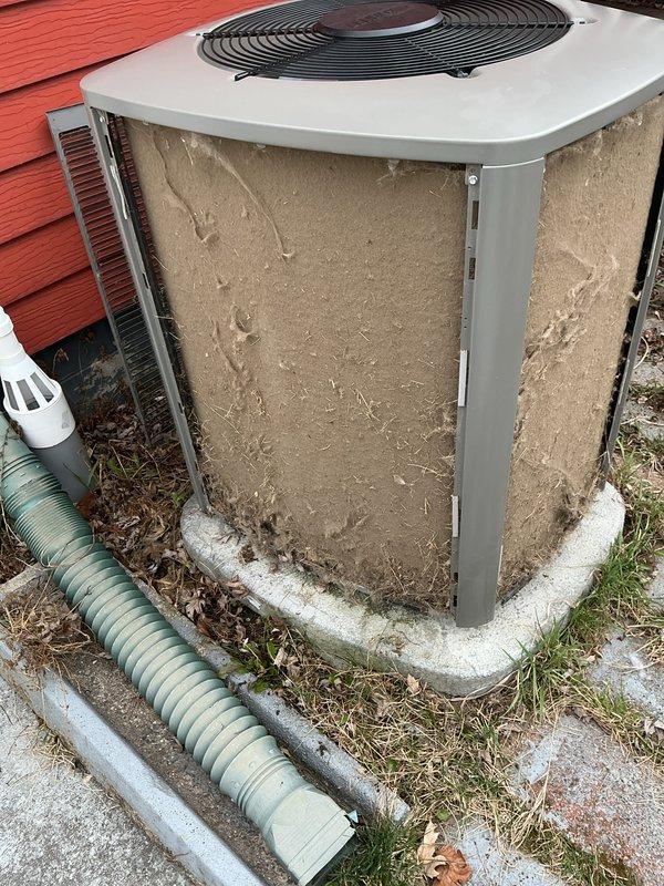 Completed annual cooling maintenance on outdoor condensing unit. Opened access panel and discovered heavily clogged air filter with significant accumulation of dirt, dust, and debris causing restricted airflow. Removed and replaced soiled filter with new unit to restore proper system operation and efficiency.