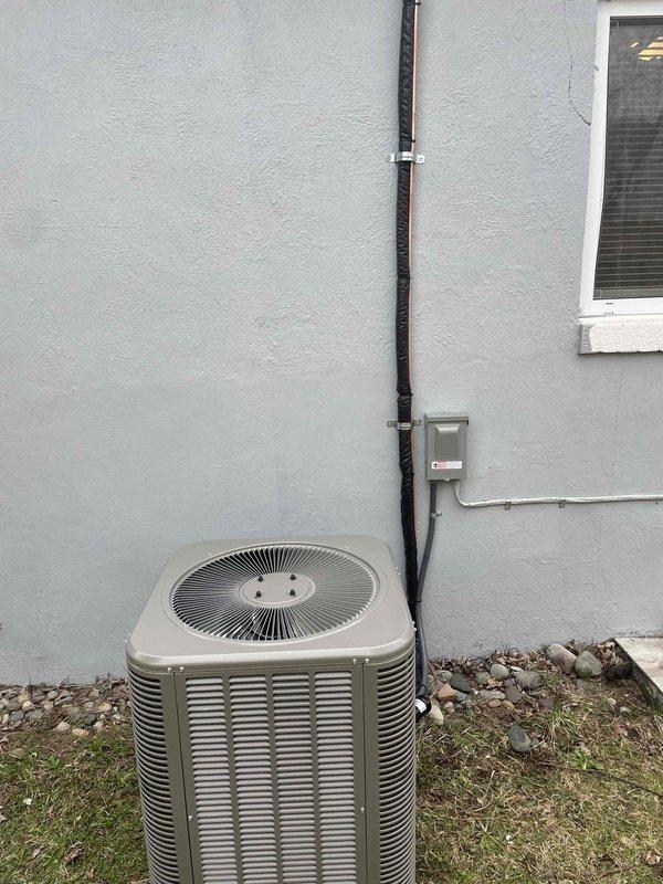 Completed installation of 2-ton air conditioning system with matching evaporator coil at rear of residence. Installed new outdoor condenser unit on protective pad with proper clearances, ran new electrical circuit with disconnect box and conduit mounted to exterior wall, and secured all necessary mechanical and electrical permits prior to installation. System tested and operational upon completion.