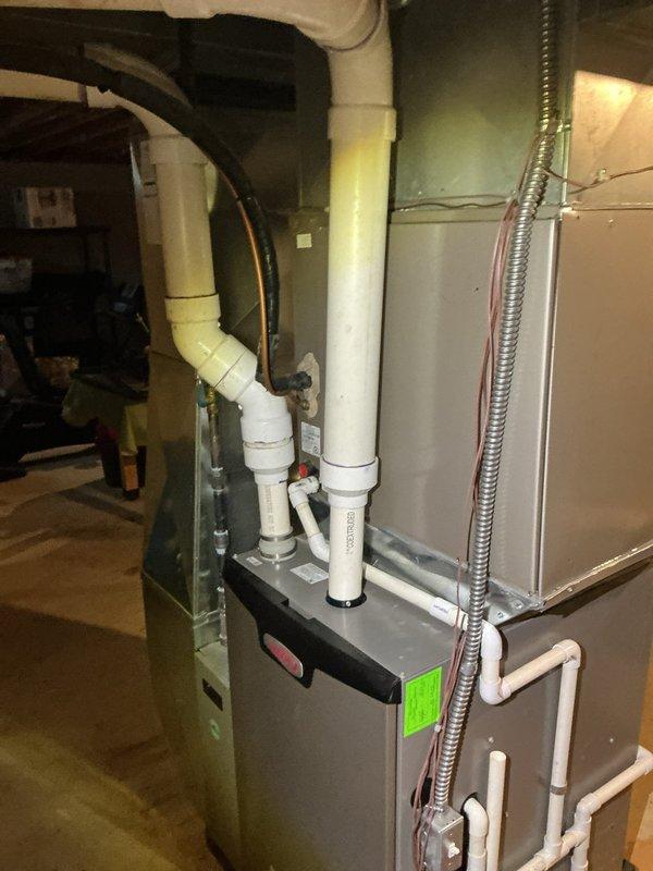 Completed annual cooling maintenance on residential HVAC system. Inspected furnace and air handler in basement mechanical room, verified proper operation of all components including condensate drainage system and electrical connections. Removed substantial accumulation of leaves and organic debris from outdoor condenser unit base, cleaned interior compartment, and inspected capacitor and wiring connections which showed signs of weathering but remained functional.