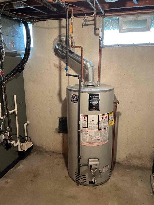 Responded to service call for water intrusion through water heater vent during heavy rainfall. Upon inspection, identified improper vent termination allowing rainwater to enter the flue system and drip from the atmospheric vent hood. Examined the galvanized vent pipe configuration and confirmed lack of adequate weather protection at the exterior termination point. Recommended installation of a proper vent cap or rain collar to prevent future water infiltration while maintaining proper draft and combustion air requirements for the natural draft gas water heater.