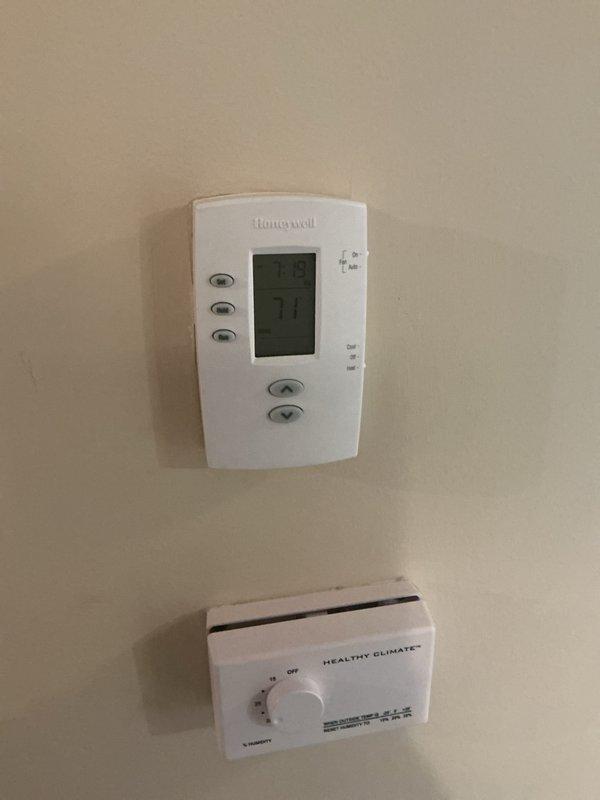 Completed routine ACM preventive maintenance on residential HVAC system. Inspected air handler unit in attic space, verified thermostat operation on Honeywell digital control and Healthy Climate accessory unit, and documented system condition with copper refrigerant lines showing age-appropriate patina but maintaining integrity. All components functioning within normal parameters with filter and controls operating properly.